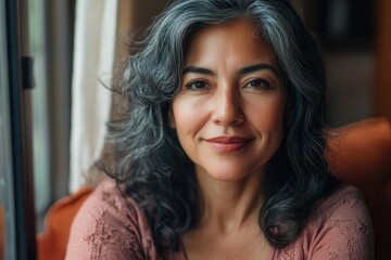 Fototapeta premium authentic portrait of mature latina woman with natural beauty soft window light illuminating her confident selfcare moment