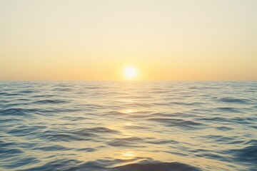 Fototapeta premium Golden sun rises over calm ocean waves, creating serene atmosphe