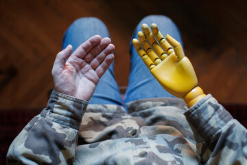 Disabled soldier veteran looking at prosthetic hand