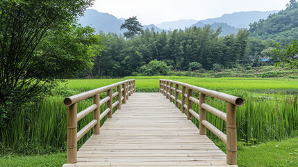 Obraz premium serene wooden bridge leads through lush green rice fields, surrounded by mountains and trees, creating peaceful landscape