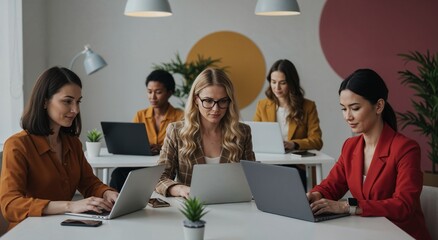 Diverse businesswomen working on laptops in modern office, multi-ethnic female team, collaboration, technology, workplace
