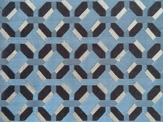 Close up of blue fabric in random geometric hexagon, and diamond pattern. Blue and black fabric in abstract modern geometrical texture. Seamless fabric background texture