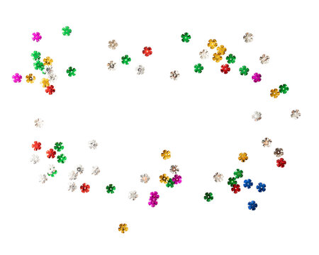 Colorful flower shaped sequins scattered on transparency background create vibrant and playful atmosphere