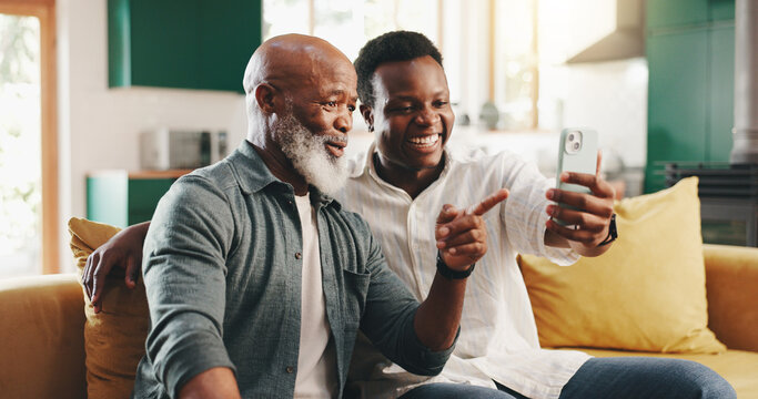 Happy, black family and father with phone on sofa for social media, network or app assistance at home. Male people, mature dad and son with smile on mobile smartphone for tech tips or software update