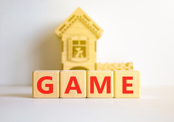 Game symbol. Concept word Game on beautiful wooden blocks. Beautiful white table white background. Wooden beautiful house. Business, lifestyle and game concept. Copy space.