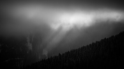 Fototapeta premium sunbeams and fog on the mountains in black white