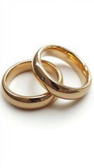 Golden wedding rings intertwined on a white background symbolizing commitment love and marriage with a clean and elegant aesthetic perfect for stock photography