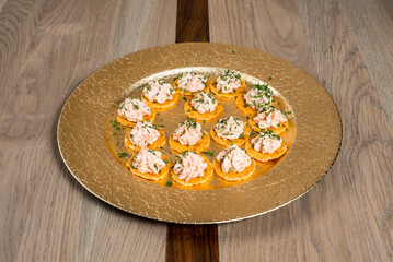 Elegant platter of cracker appetizers topped with creamy dip and fresh herbs for a sophisticated treat