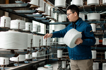 Asian men are working in a textile factory.