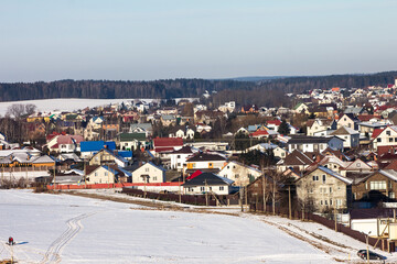 winter photography of a snowy suburban neighborhood, showcasing snow-covered houses and trees in a peaceful setting, perfect for seasonal marketing and landscape visuals.