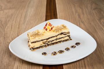 Delicious layered cake topped with crumb and decorative piece served on a modern white plate