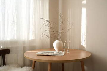 A serene minimalist setup with a wooden table, stylish plate, elegant vase with dry branches and...