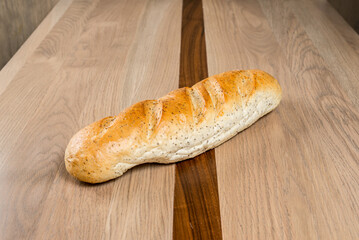 Loaf of bread freshly baked and ready to enjoy resting on a wooden table Bakery food concept
