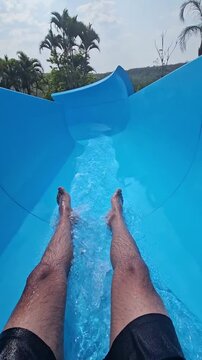 man going down the slide in the water park. water recreation activity. vacation and summer concept.