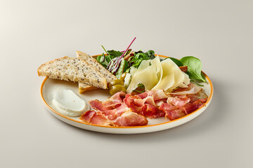 Gourmet Antipasti Plate Against a Minimalist Background Parmegiano, Prosciutto, Olives, Cream Cheese, Toasts