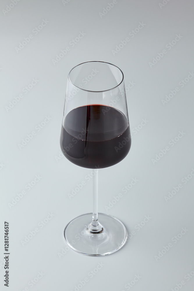Poster elegant minimalist photograph of a red wine glass on a neutral background with soft lighting