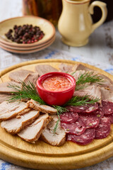 Gourmet Meat Assortment with Veal Tongue on Rustic Wooden Platter Surrounded by Natural Decor and Warm Color Tones