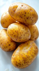 Freshly harvested golden potatoes stacked on a clean surface ready for cooking