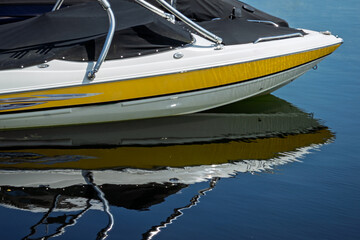 Close up of the front bow of a speedboat and its reflection on water