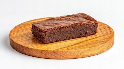 A delicious-looking chocolate brownie sits on a wooden board.  Rich, dark, and decadent.