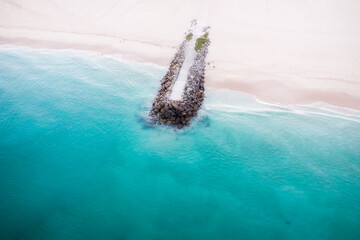 drone aerial view of breakwater on beach shoreline