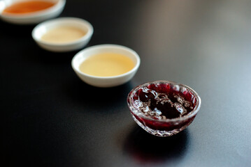red currant jam and honey in bowls on the black background