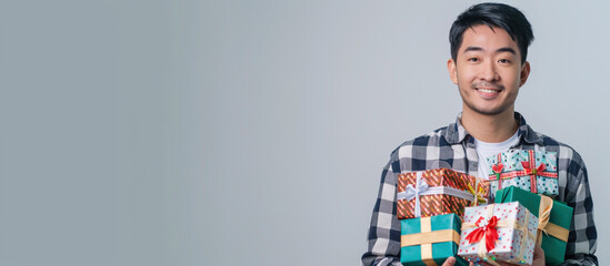 Asian man holding gift box with bow on gray background. Satisfaction and excellent service. Delightful deliveries with a focus on customer happiness. Copy paste empty space for text