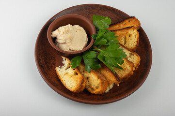 Traditional rustic appetizer dish with slices of toasted white bread with bacon spread and fresh parsley on a ceramic plate. Authentic Eastern European cuisine close-up, top view, side view