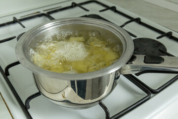 boiling potatoes in stainless steel pot on gas stove