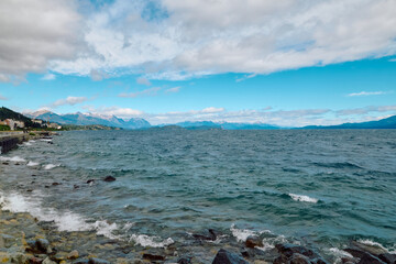 Huge lake surrounded by rocky mountains under blue, bright sky