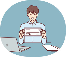 Businessman with paycheck sits at office desk with laptop showing off investments in start-ups from large corporations. Man with paycheck at his workplace demonstrates certificate for large amount