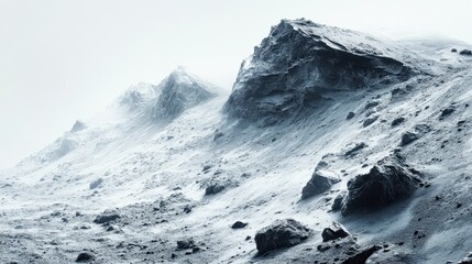 Snow-covered mountain landscape with rocky formations and misty atmosphere in the background