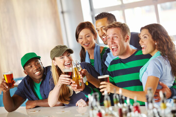 Beer, sports and friends in pub with cheers, game and celebration for support together. Excited, winning and group of people with alcohol, drink and broadcast television for team match in bar