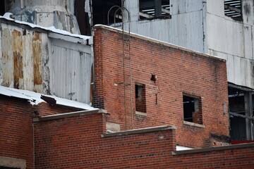 Closed factory, red brick construction, ladder leading to roof.
