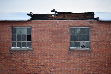 Abandoned factory, broken windows and ruined roof.