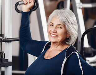 Fototapeta premium Starsza pani ćwiczy na siłowni zajęcia dla seniorów