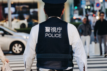 Japanese police squad formation in protective uniform with "Police" logo, policemen patrol maintain public during political demonstration protest rally in the streets of Tokyo city center, Japan