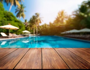 Fototapeta premium empty wood table top and blurred swimming pool in tropical resort in summer banner background can used for display or montage your products