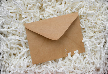 Envelope on white corrugated shredded paper for filling gift boxes and baskets. Concepts for backdrops, gift and decorative papers.