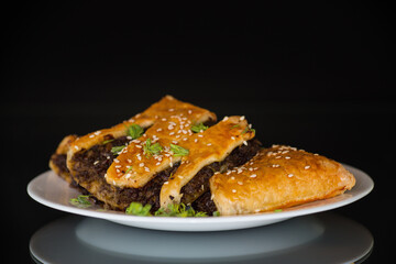 cooked simple puff pastries with mushroom filling isolated on black background