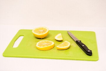 Fresh Lemon Slices and Knife on Green Cutting Board