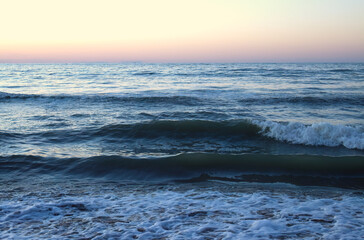 Sunset at the sea in Italy, Rimini coast, big waves at sunset, high waves at the beach, Cattolica sea, goutweed at the sandy beach, foaming goutweed