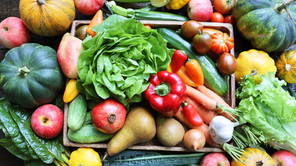 Organic vegetables from the garden - carrots, tomatoes, peppers, cucumbers, lettuce and fruits in wooden box . Raw healthy food concept. Top view