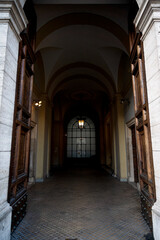 A grand arched hallway with open wooden doors and a glowing lantern