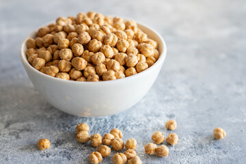 Roasted chickpeas in bowl on wooden background, traditional turkish nut, leblebi