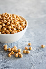 Roasted chickpeas in bowl on wooden background, traditional turkish nut, leblebi