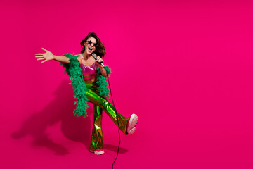 Energetic woman singing against a vibrant magenta background in colorful retro-styled fashion