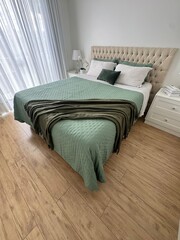 quarto com cama arrumada na cor verde