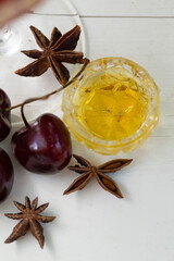 Cherries, star anise, and golden liqueur in a crystal glass