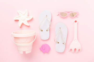 Children's flip-flops and beach toys on color background,,top view